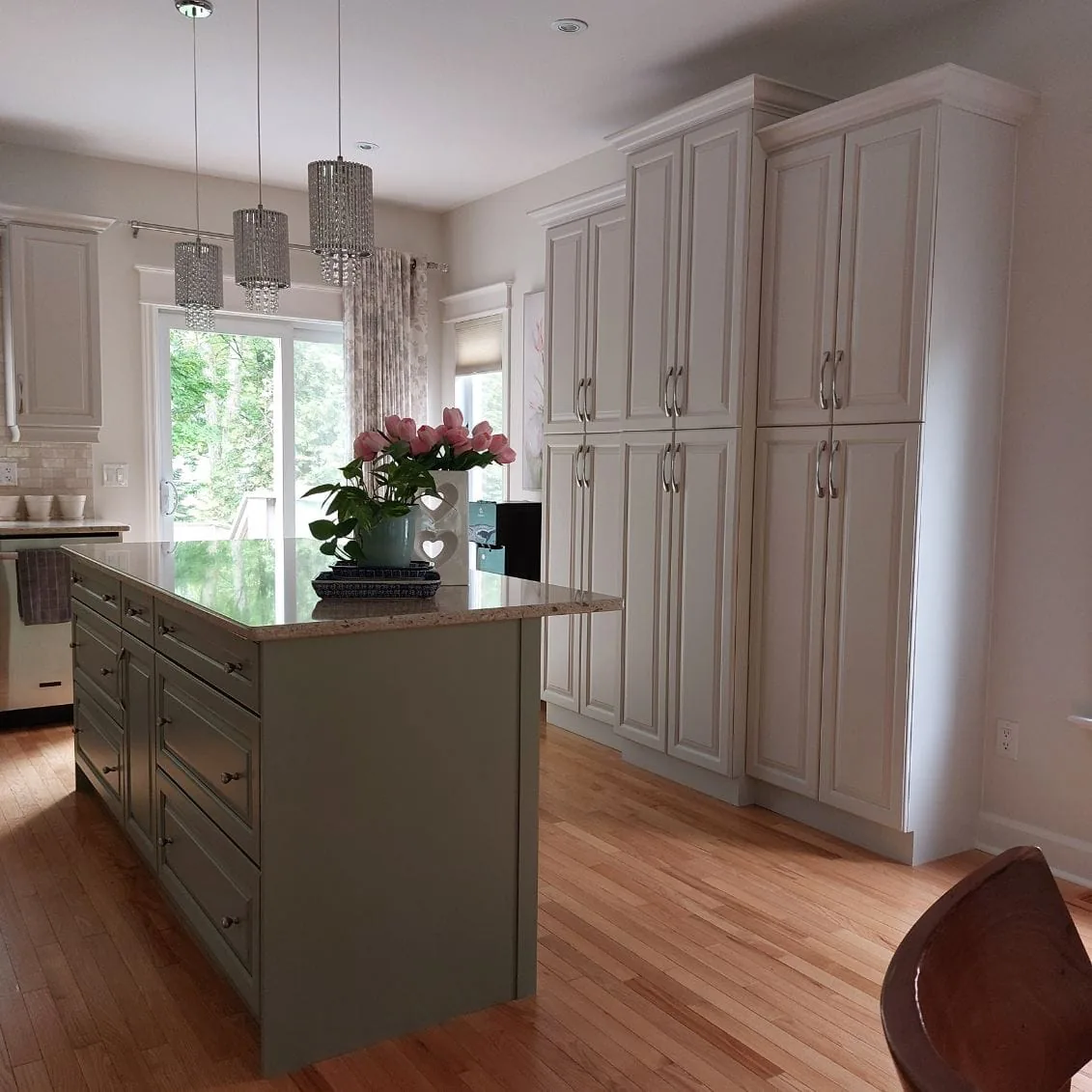 Pantry Cabinets & Sage Island: White spray-finished pantry wall with a sage green island